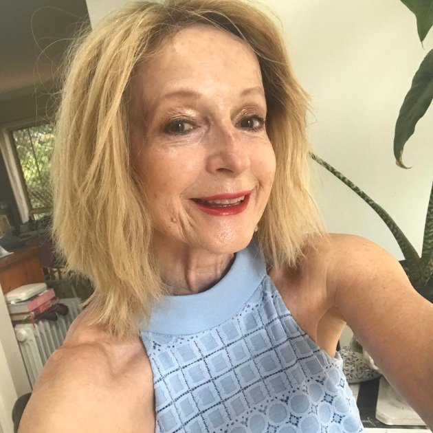 Smiling woman in blue dress indoor selfie